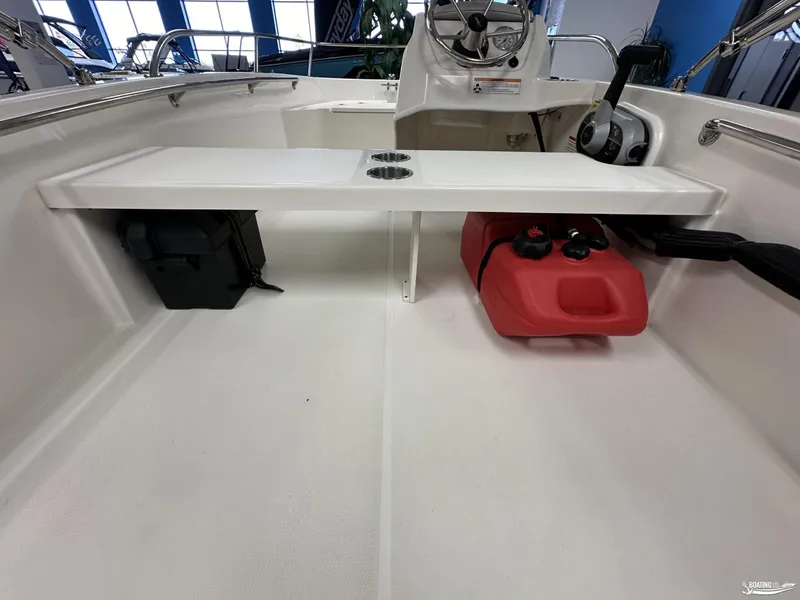 Slide: The Image of 2024 Boston Whaler 130 Super Sport interior with steering console and storage compartments. - 7