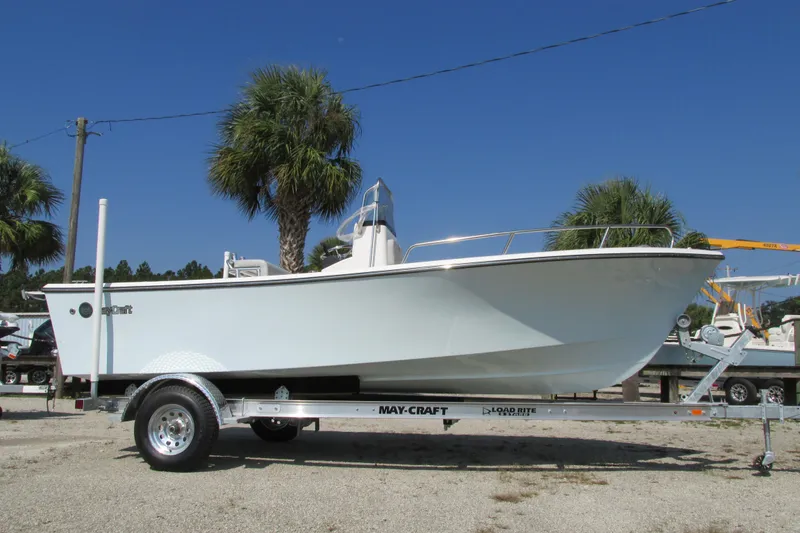 Slide: The Image of 2023 May-Craft 1900CC boat on trailer, parked outdoors with palm trees in the background. - 2