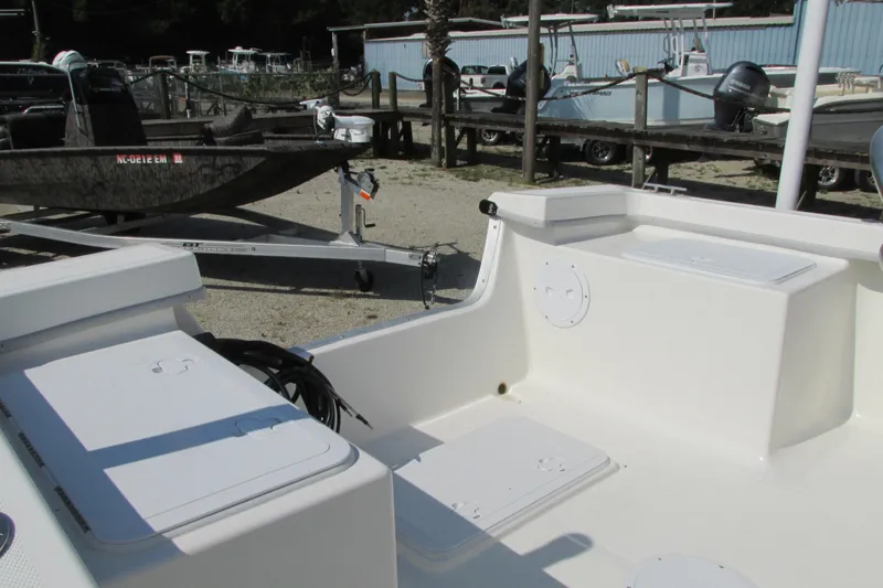 Slide: The Image of 2023 May-Craft 1900CC boat interior with storage compartments and trailer in background. - 7