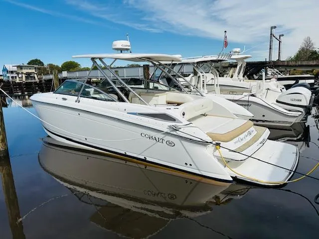 The Image of 2015 Cobalt 302 boat docked in a marina on a sunny day. - 1