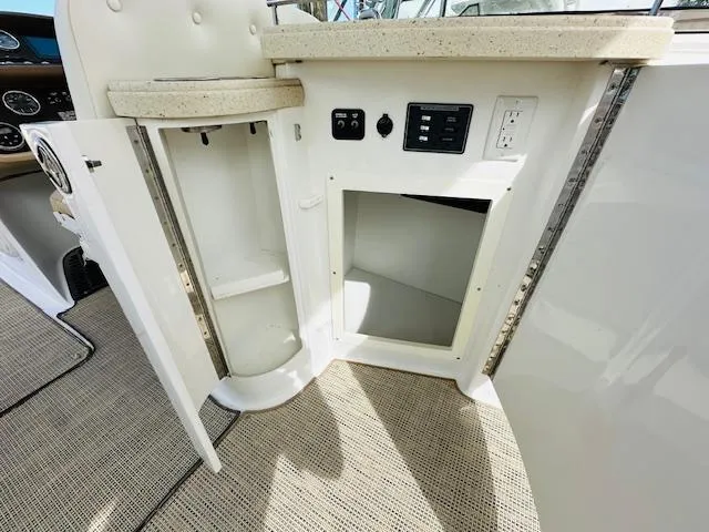 Slide: The Image of 2015 Cobalt 302 boat interior with open storage compartments and control panel. - 12
