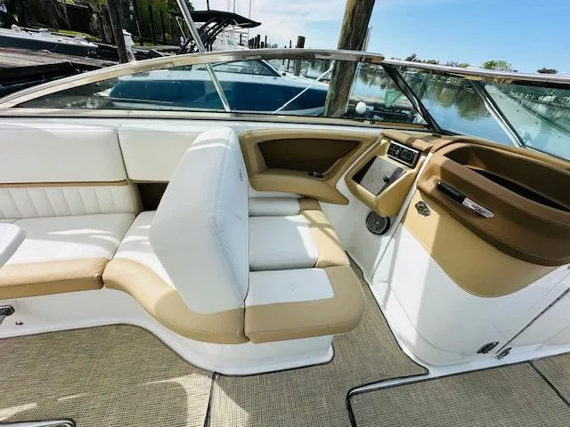 Slide: The Image of 2015 Cobalt 302 boat interior with white and tan seating, docked at marina. - 14