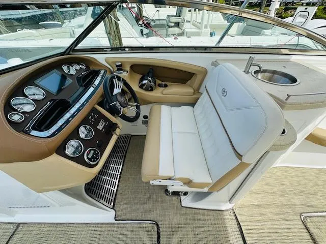 Slide: The Image of 2015 Cobalt 302 boat cockpit with steering wheel, gauges, and seating. - 15