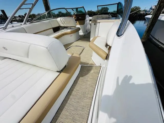 Slide: The Image of 2015 Cobalt 302 boat interior with white and tan seating, docked by the water. - 7