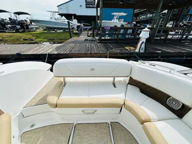 Slide: The Image of 2015 Cobalt 302 boat interior with beige and white seating at a marina. - 8