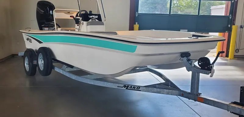 Slide: The Image of 2023 Mako Pro Skiff 17 CC boat on trailer in a garage. - 1