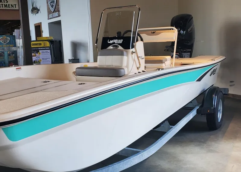 Slide: The Image of 2023 Mako Pro Skiff 17 CC boat on trailer in showroom. - 2