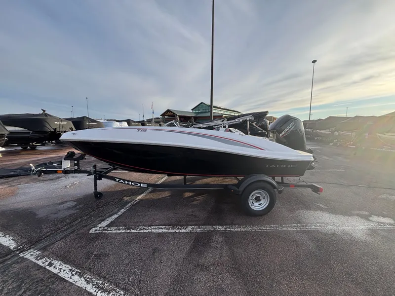 The Image of 2023 Tahoe T16 boat on trailer in parking lot, overcast sky. - 0