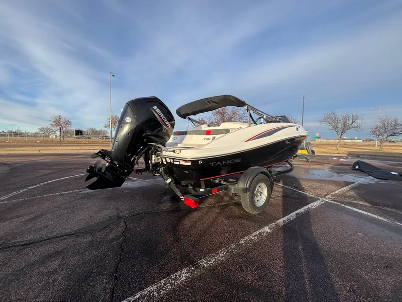 Slide: The Image of 2023 Tahoe T16 boat on trailer in parking lot, under clear sky. - 3