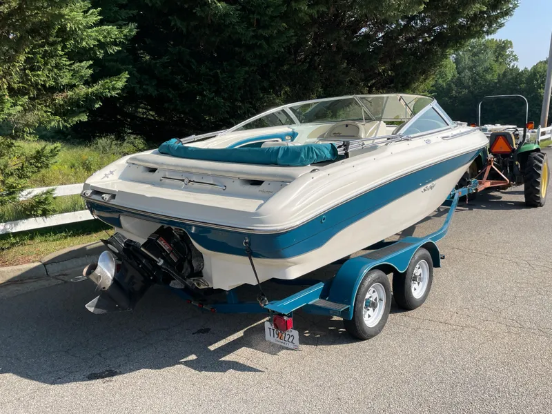 Slide: The Image of 1997 Sea Ray 190 Signature boat on trailer, parked on a sunny road. - 3