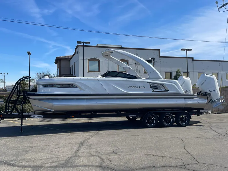 The Image of 2025 Avalon 2785 Excalibur Elite-Carbon Fiber boat on trailer, parked outdoors. - 0