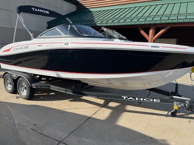 Slide: The Image of 2023 Tahoe 210 Si boat on trailer, black and white design, parked outdoors. - 1