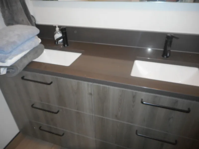 Slide: The Image of Double sink bathroom vanity with dark wood finish and modern black fixtures, Adonia Obsession Trip #12. - 19