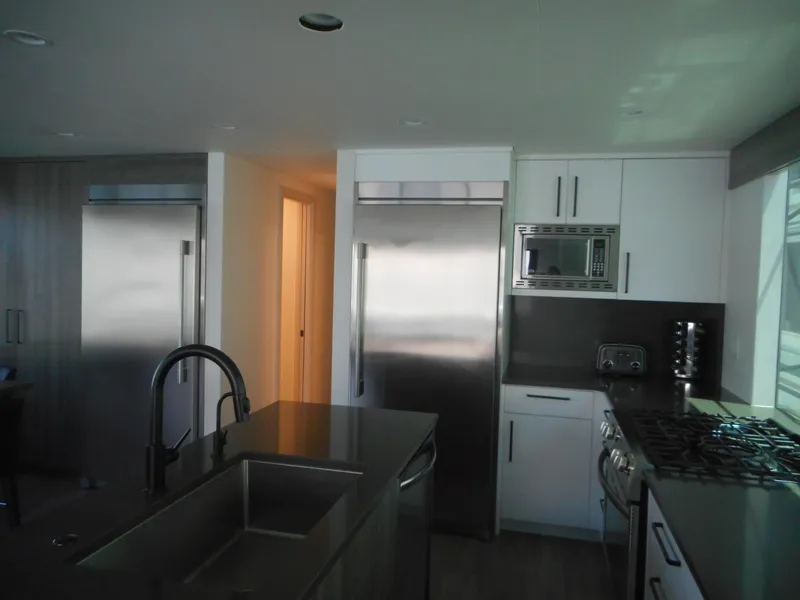 Slide: The Image of Modern kitchen with stainless steel appliances, island sink, and sleek cabinetry. Adonia Obsession Trip #12, 2021. - 27