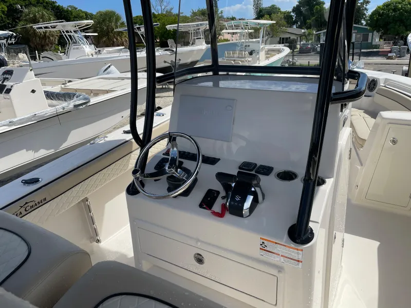 Slide: The Image of 2023 Sea Chaser 27 HFC boat console with steering wheel and controls. - 10
