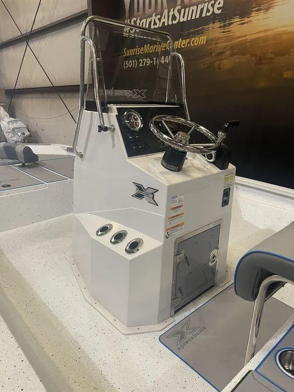 Slide: The Image of 2023 Xpress H190B boat console with steering wheel and controls in showroom. - 2