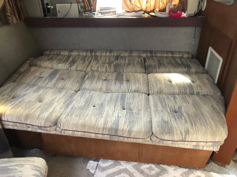 Slide: The Image of 1986 Cruisers ESPRIT 3370 interior with cushioned seating area. - 9