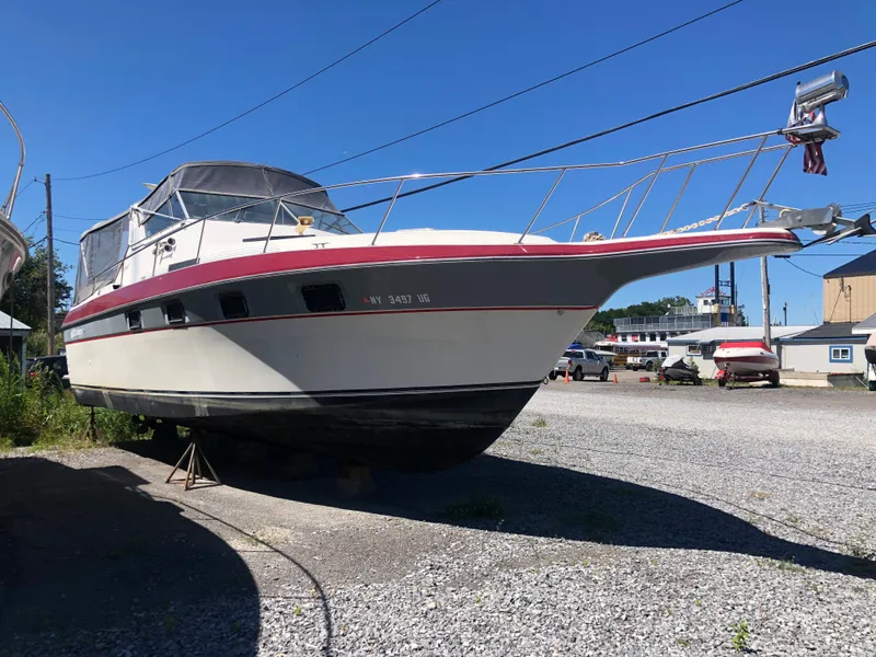 The Image of 1986 Cruisers ESPRIT 3370 boat on dry dock in a marina. - 1