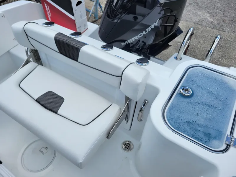 Slide: The Image of 2023 Wellcraft 222 Fisherman boat interior with Mercury engine and seating. - 2