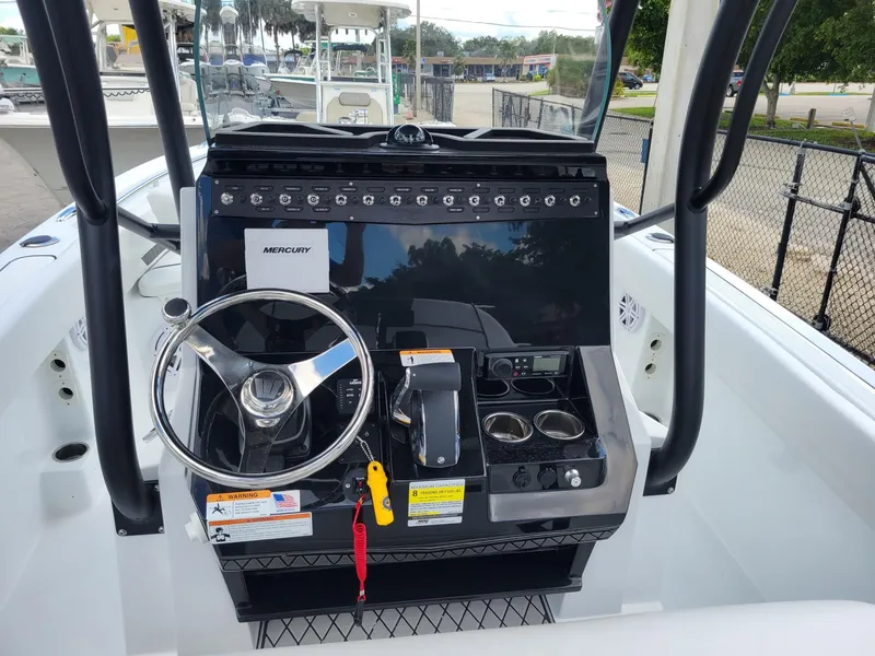Slide: The Image of 2023 Wellcraft 222 Fisherman boat console with steering wheel and controls. - 3