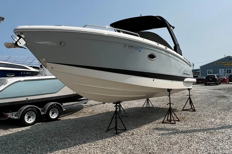 Slide: The Image of 2019 Chaparral 277 SSX boat on stands in a gravel lot, side view. - 2