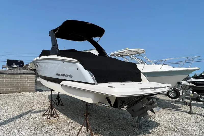 Slide: The Image of 2019 Chaparral 277 SSX boat on stands, covered, with clear blue sky background. - 3