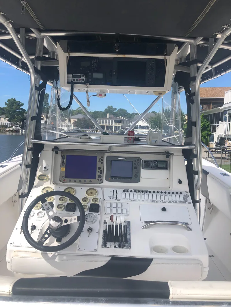 Slide: The Image of 2003 Fountain 38TE boat dashboard with steering wheel, navigation screens, and control panel. - 15