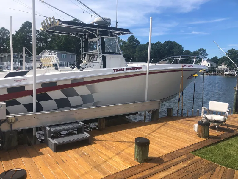 Slide: The Image of 2003 Fountain 38TE boat docked on a wooden pier by a lake. - 3