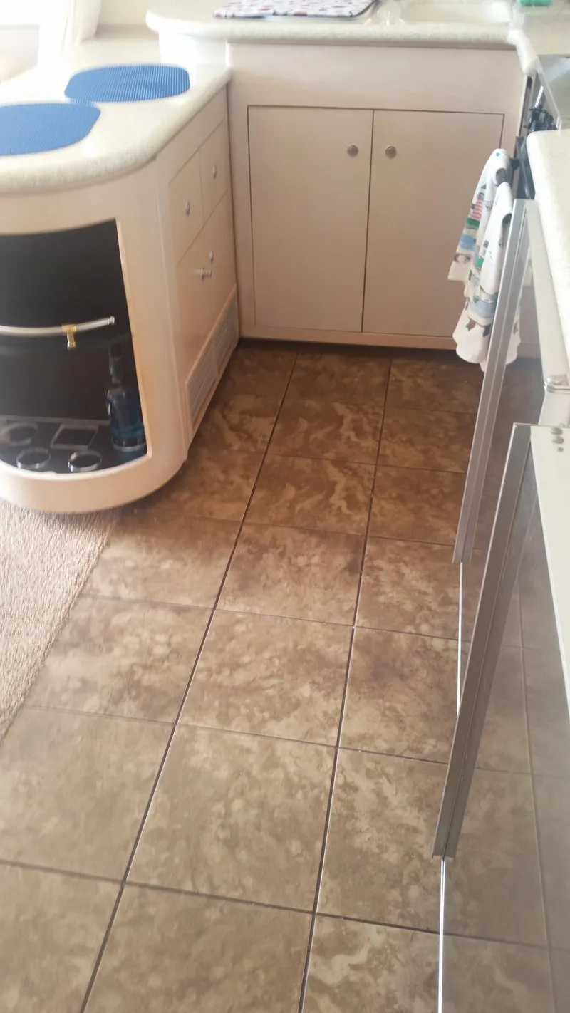 Slide: The Image of 1999 Carver 530 Voyager Pilothouse kitchen with tiled floor and cabinetry. - 20