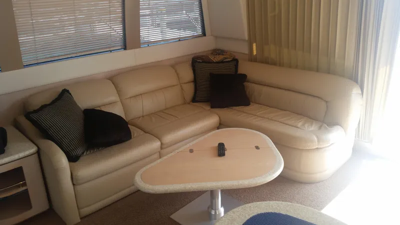 Slide: The Image of 1999 Carver 530 Voyager Pilothouse interior with beige leather sofa and modern table. - 25