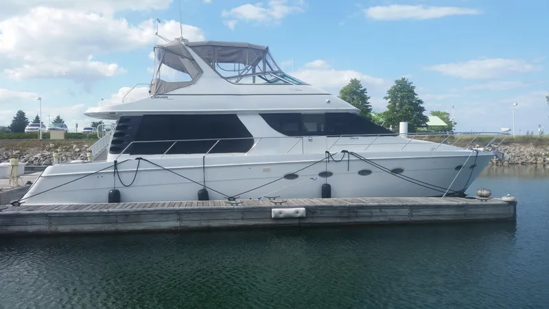 The Image of 1999 Carver 530 Voyager Pilothouse yacht docked at a marina. - 0