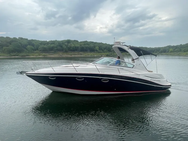 Slide: The Image of 2009 Four Winns V318 boat on a calm lake with a forested background. - 1
