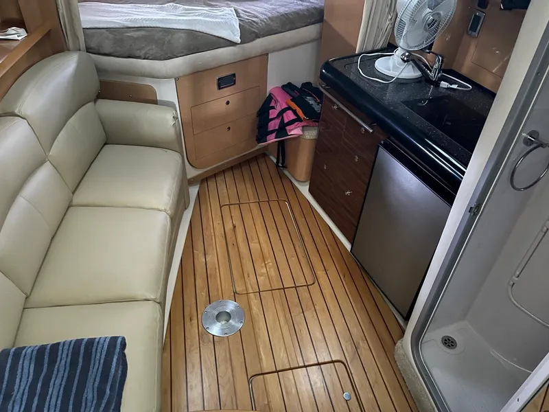 Slide: The Image of 2009 Four Winns V318 cabin interior with kitchenette, sofa, and bed. - 12