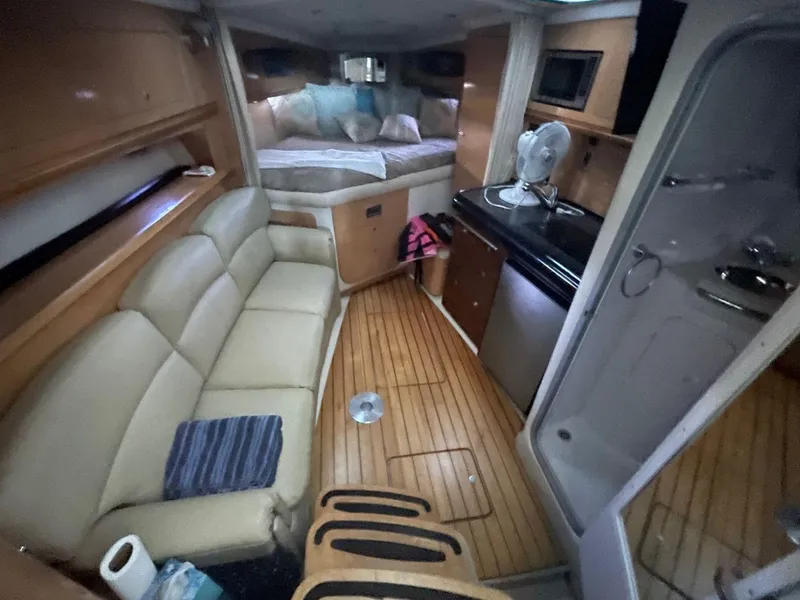 Slide: The Image of 2009 Four Winns V318 cabin interior with seating, kitchenette, and bed. - 13