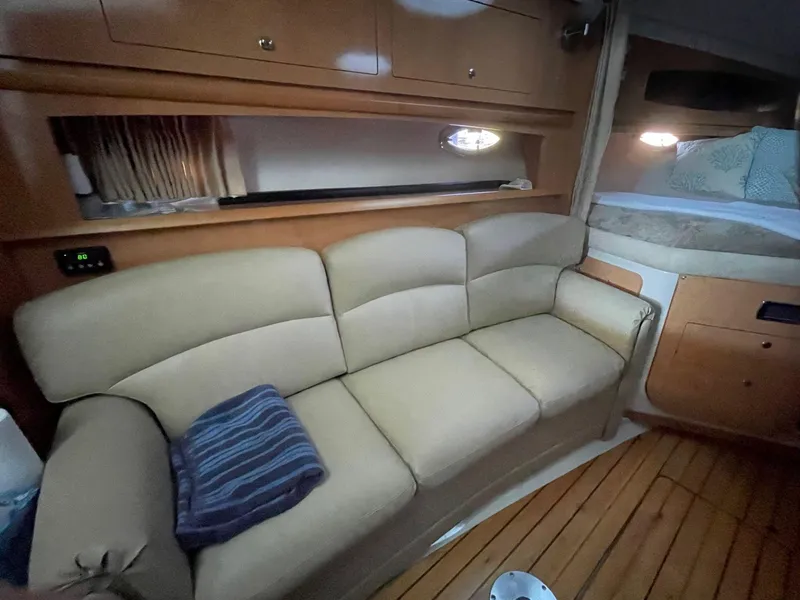 Slide: The Image of 2009 Four Winns V318 interior with beige leather sofa and wooden flooring. - 15