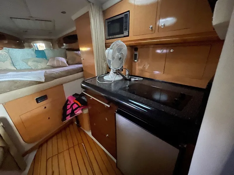 Slide: The Image of 2009 Four Winns V318 boat interior with kitchenette and sleeping area. - 16