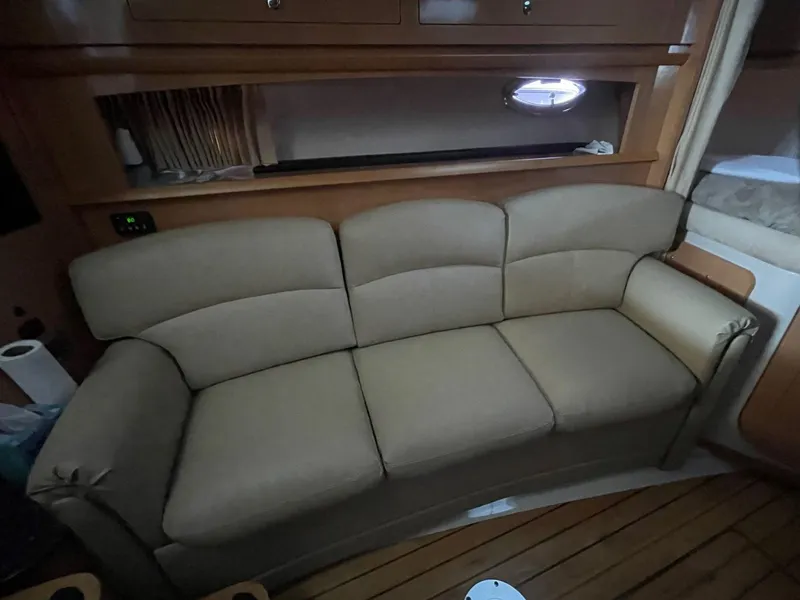 Slide: The Image of 2009 Four Winns V318 interior with beige sofa and wooden flooring. - 17