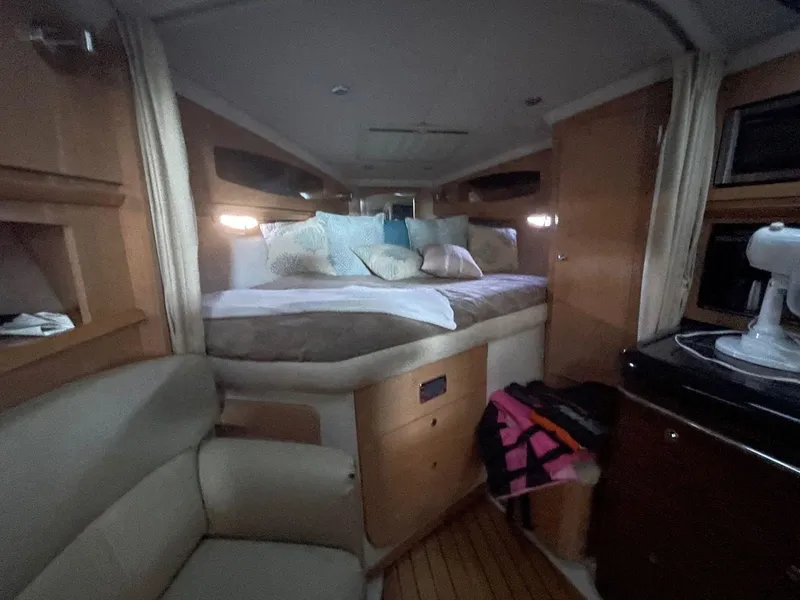 Slide: The Image of 2009 Four Winns V318 cabin interior with bed, seating, and kitchenette. - 18