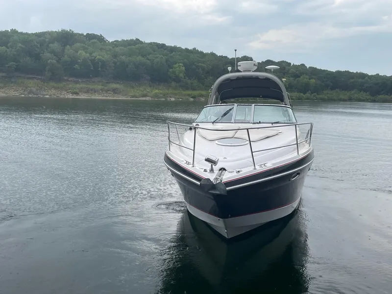 Slide: The Image of 2009 Four Winns V318 boat on a calm lake with forested shoreline. - 2