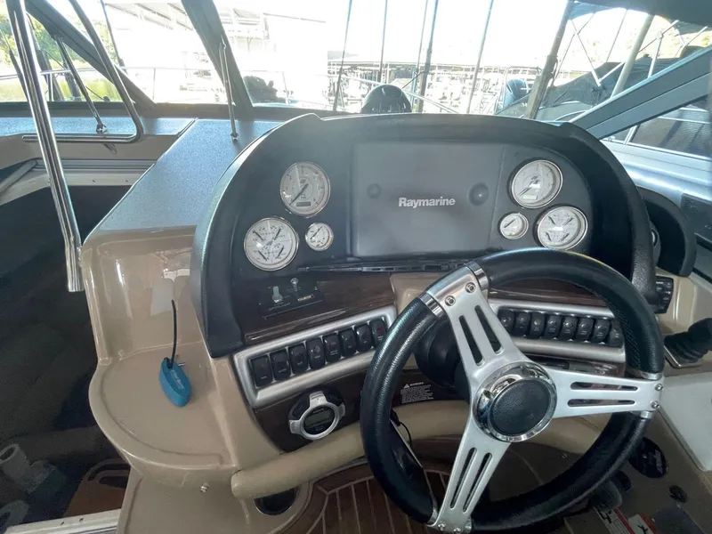 Slide: The Image of 2009 Four Winns V318 boat dashboard with Raymarine navigation system and gauges. - 24