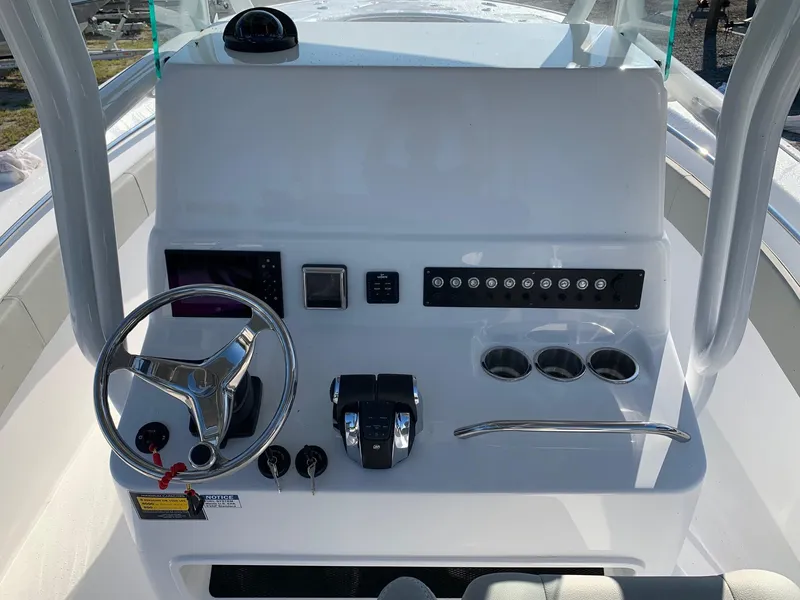 Slide: The Image of 2024 Cape Horn 31T boat console with steering wheel, controls, and cup holders. - 9