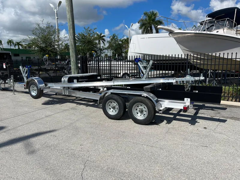 Slide: The Image of 2023 Trailer TRAILERS model, dual-axle boat trailer in a parking lot. - 0