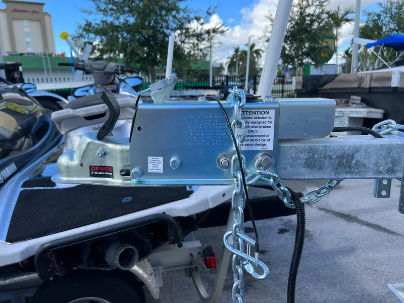 Slide: The Image of 2023 Trailer model with hitch and safety chains in a parking lot. - 10