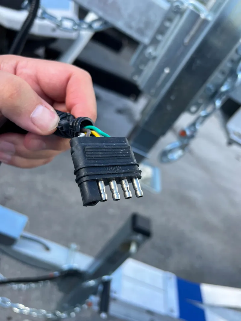 Slide: The Image of Hand holding a 2023 trailer electrical connector plug. - 14
