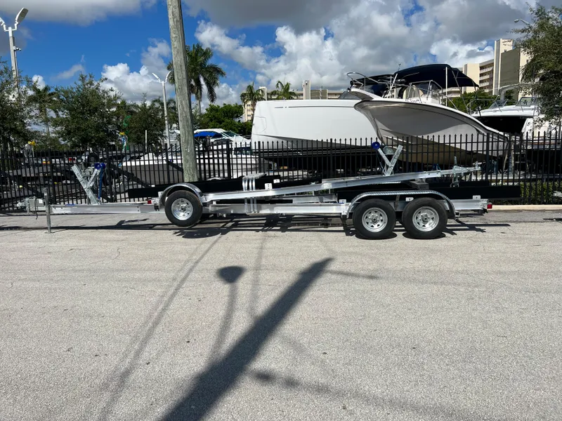 Slide: The Image of 2023 Trailer TRAILERS model parked near boats under a sunny sky. - 22