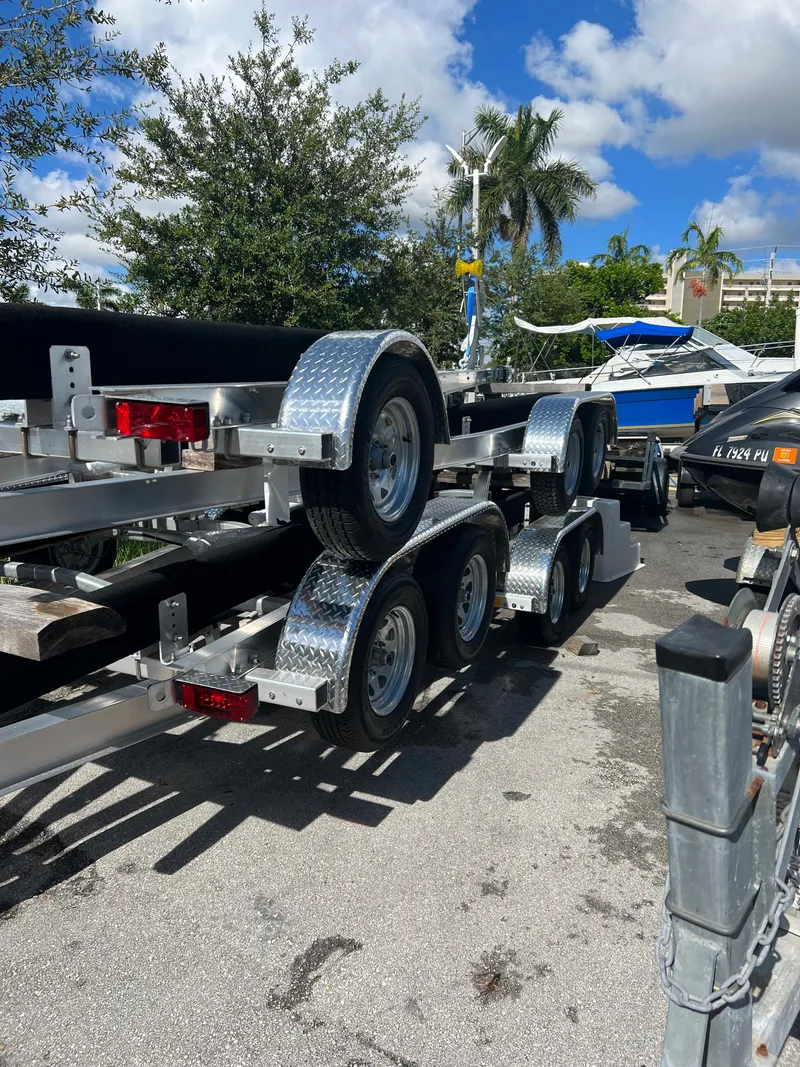 Slide: The Image of 2023 Trailer TRAILERS model parked near boats under a sunny sky. - 5