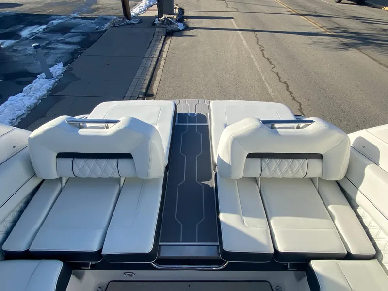 Slide: The Image of 2023 Regal LS6 Surf boat with white cushioned seating and sleek design. - 10