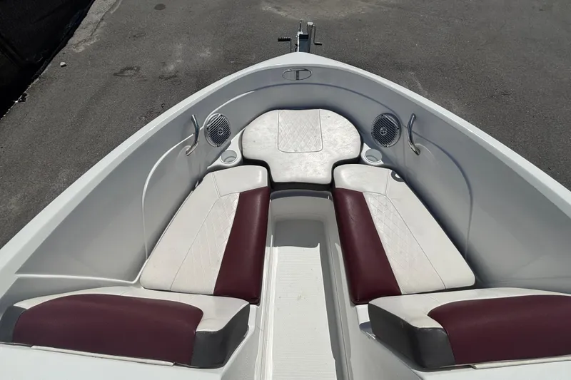 Slide: The Image of 2019 Tahoe 550 TF boat interior with white and maroon seating, speakers, and cup holders. - 32