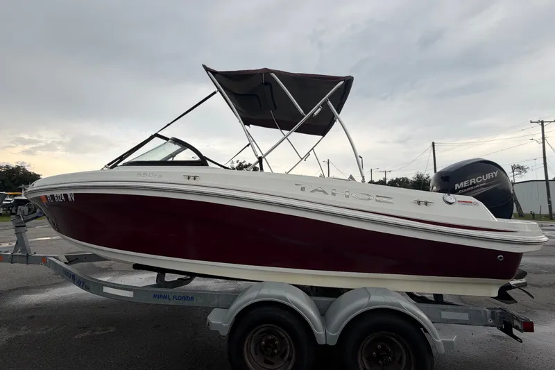 Slide: The Image of 2019 Tahoe 550 TS boat on trailer, featuring a sleek maroon and white design. - 6
