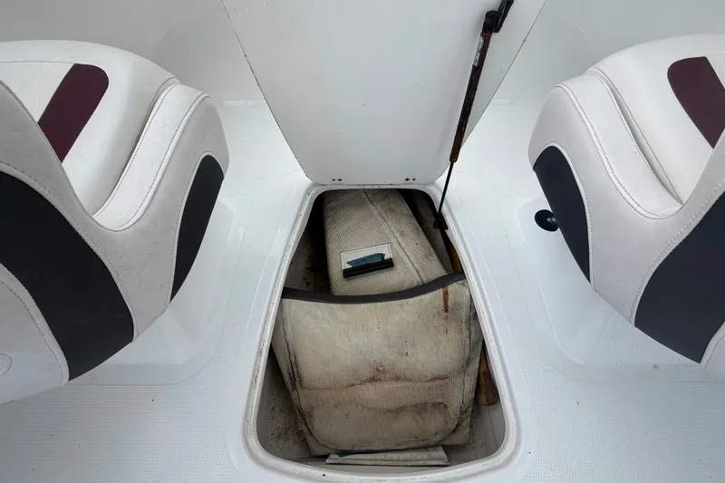 Slide: The Image of 2019 Tahoe 550 TS boat interior with open storage compartment between seats. - 17